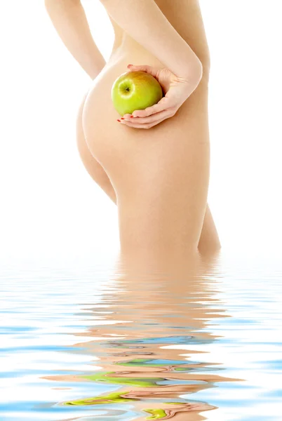 stock image Naked woman with green apple in water