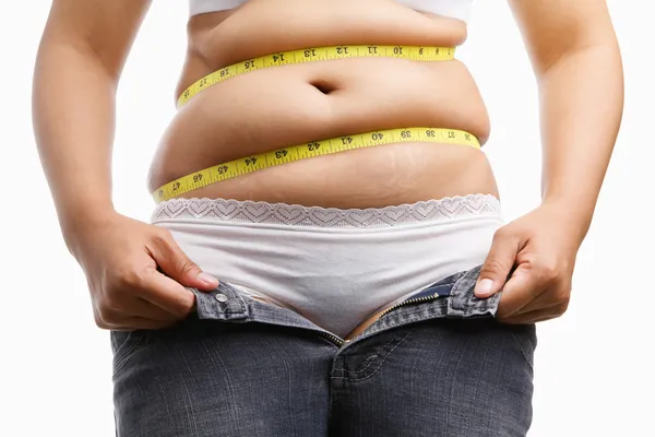 Mulher gorda segurando seu jeans unzip — Fotografia de Stock