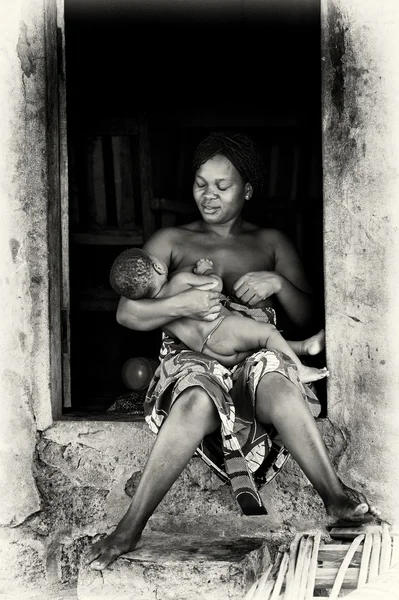stock image Benin woman feeds her child