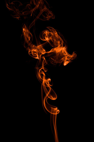 Photo of a smooth orange abstract column of smoke creating shapes on a black background